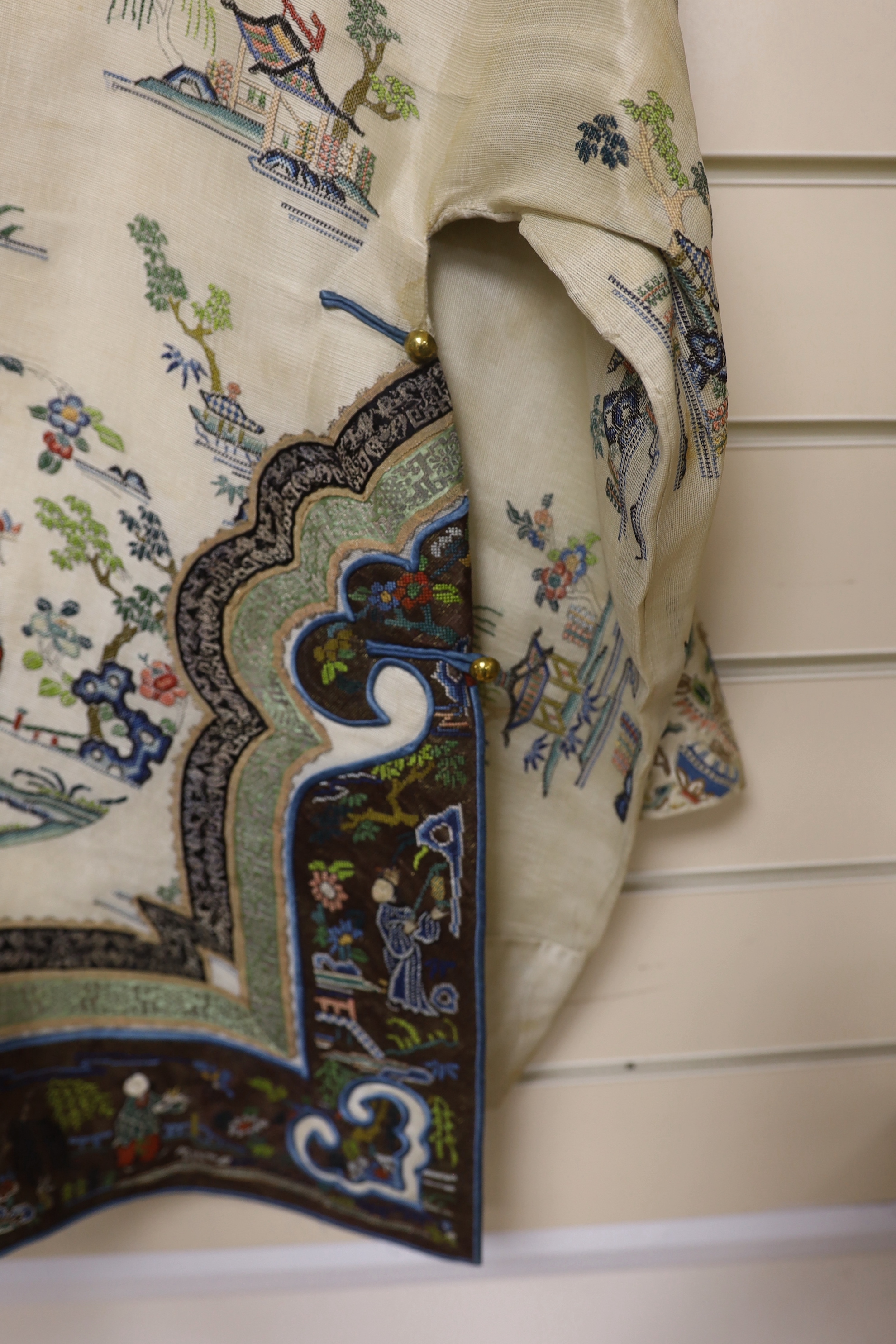 A late 19th/early 20th century Chinese gauze summer robe embroidered with flowers, figures and pagodas, 85cm high